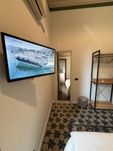 a flat screen tv on the wall of a bedroom at Domus Divina in Cefalù