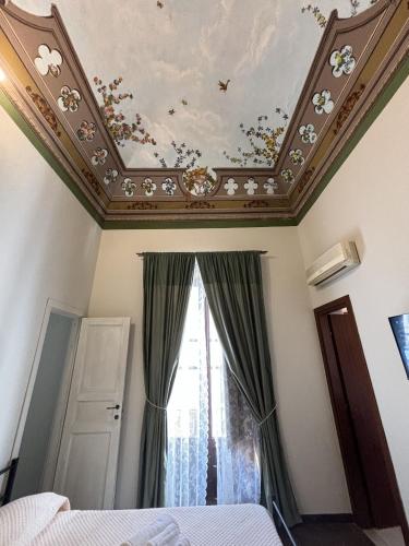 a bedroom with a coffered ceiling with flowers on the ceiling at Domus Divina in Cefalù