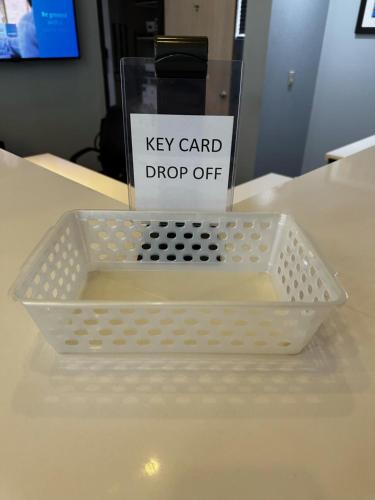a white tray on a table with a key card drop off sign at Best Western Little River Inn in Simcoe