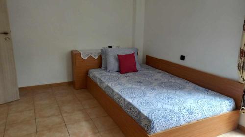 - une petite chambre avec un lit et un oreiller rouge dans l'établissement Апартамент-идеален център Ямбол, à Yambol
