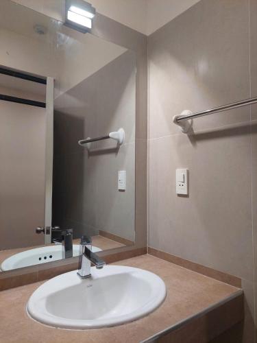 a bathroom with a sink and a large mirror at Hotel San Cristobal in San Cristóbal