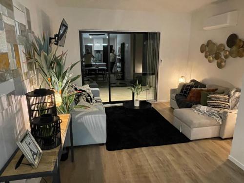a living room with a couch and a table at Flat Bush Holiday Accomodation in Auckland