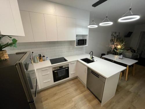 a kitchen with white cabinets and a white counter top at Flat Bush Holiday Accomodation in Auckland