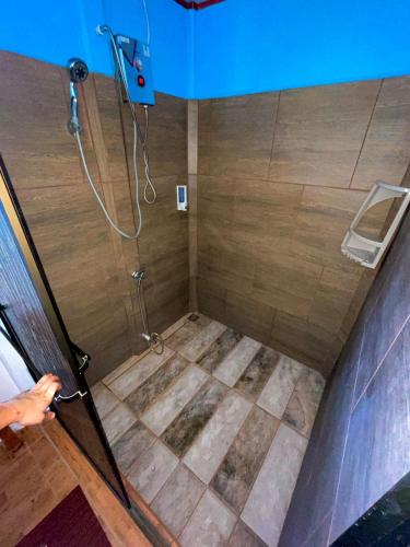 a bathroom with a shower with a tile floor at Cabañas el Bosque del Arenal in Guayabal