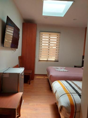 a bedroom with a bed and a flat screen tv at Hotel San Cristobal in San Cristóbal