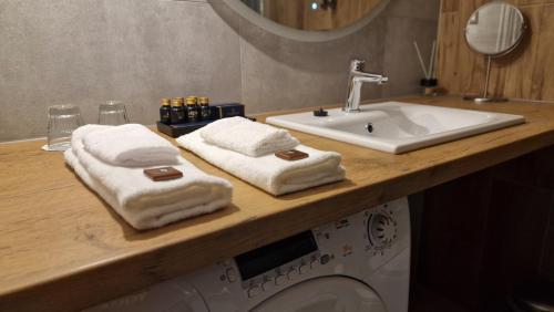 łazienka z umywalką, pralką i ręcznikami w obiekcie Alibi - Sympozjum Studio w Krakowie
