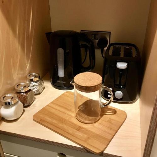 a glass jar on a wooden cutting board on a kitchen counter at Thornfield Farm Luxury Glamping Pods, The Dark Hedges, Ballycastle in Stranocum