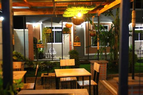 een restaurant met houten tafels, stoelen en planten bij Dahari Home Hostel in Moshi