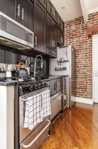 a kitchen with a stove and a refrigerator at Private Room at a 3 bedroom Apt at the heart of East Village - shared apartment in New York