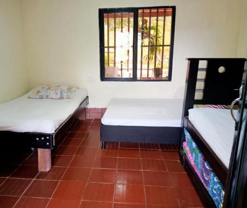 2 camas en una habitación con ventana en Munay Travel camp, en San Carlos