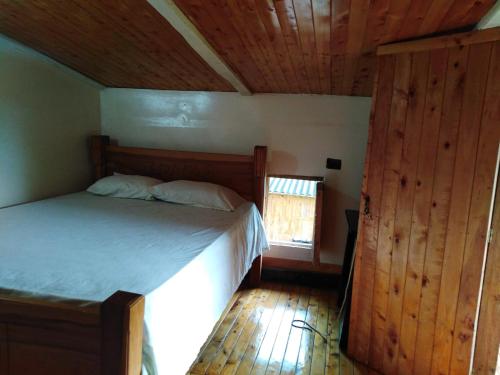 1 dormitorio con 1 cama y suelo de madera en Munay Travel camp, en San Carlos