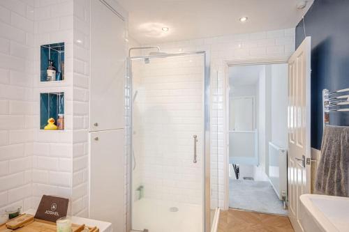 a white bathroom with a shower and a sink at A Spacious 2 Bed Home in a Central Location in Bishops Stortford