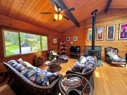 a living room with couches and a ceiling fan at Volcano Hideaway Cabin as seen on HGTV in Volcano