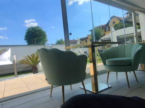 two green chairs and a table on a balcony at Infinity Passion in Rho