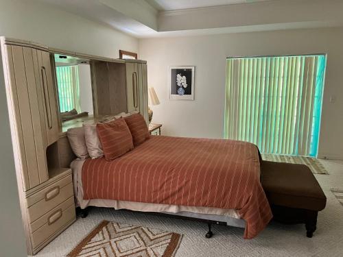 a bedroom with a bed and a dresser and a mirror at Grandma’s White House in Palm Coast