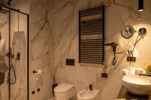 a bathroom with a toilet and a sink and a shower at La Duse Luxury Rooms in Pescara
