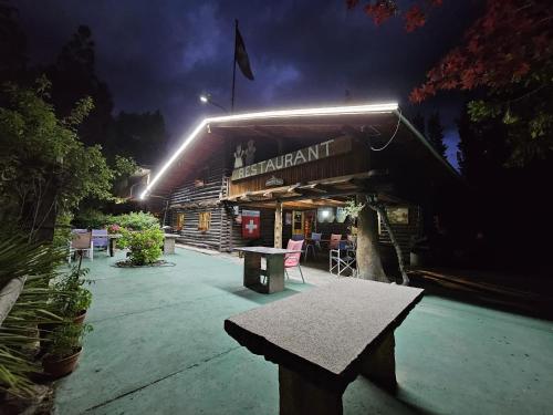 a bench in front of a building at night at Cabañas swissminiatur in Cacheuta