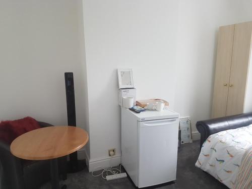 a small room with a small table and a small refrigerator at A Quiet & Comfortable 4 Bedroom house in Manchester