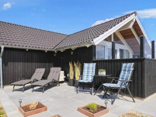 a patio with chairs and a table and a roof at 6 person holiday home in Hadsund in Øster Hurup