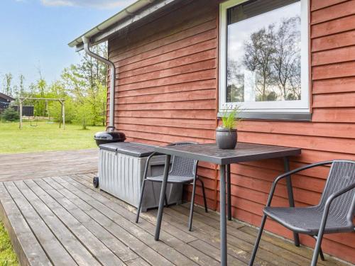 eine Terrasse mit einem Tisch und Stühlen auf einer Terrasse in der Unterkunft 6 person holiday home in Nibe in Nibe