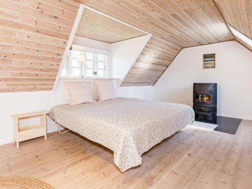 um quarto com uma cama e um fogão a lenha em Holiday home Hadsund XLVII em Hadsund