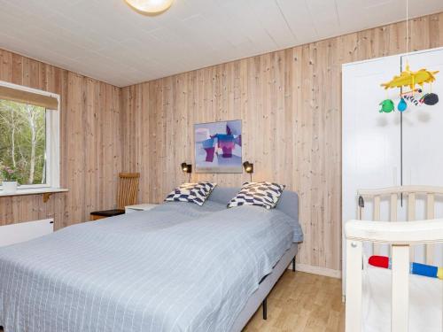 a bedroom with a bed in a room with wooden walls at 6 person holiday home in Nibe-By Traum in Nibe