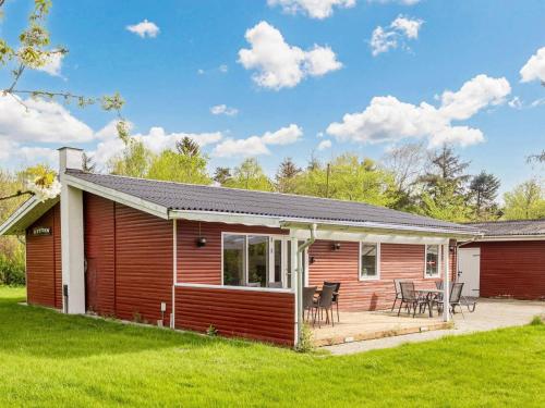 a log cabin with a deck and a patio at 6 person holiday home in Nibe-By Traum in Nibe