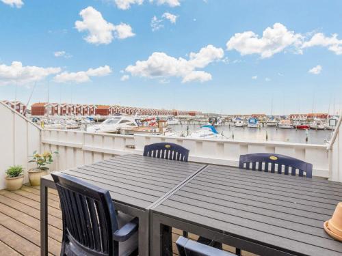 a table and chairs on a balcony with a marina at 4 person holiday home in Nibe in Nibe