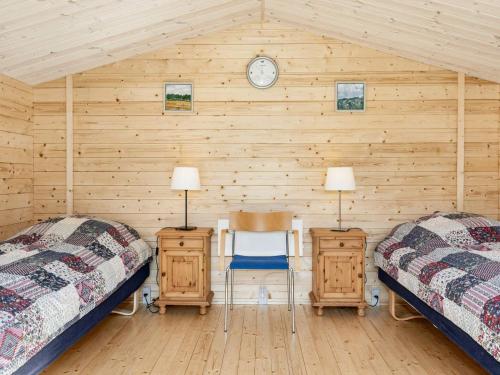 a bedroom with two beds and a clock on the wall at 4 person holiday home in Højslev-By Traum in Højslev