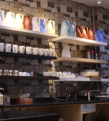 a room with shelves with ceramics on the wall at شقق زائر الشمال للشقق المخدومة in Hail