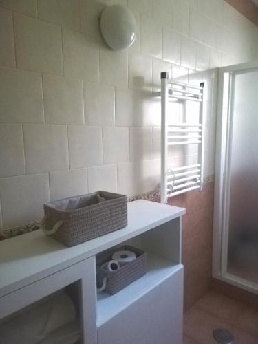 a bathroom with a white shelf with baskets on it at Casa La Parra in Tejeda