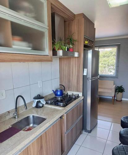 uma cozinha com um lavatório e um frigorífico de aço inoxidável em Recanto santa esmeralda em Sorocaba