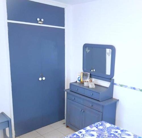Tinache Blue Marine apartment في بلايا ديل إنغلز: غرفة نوم زرقاء مع خزانة ملابس زرقاء ومرآة