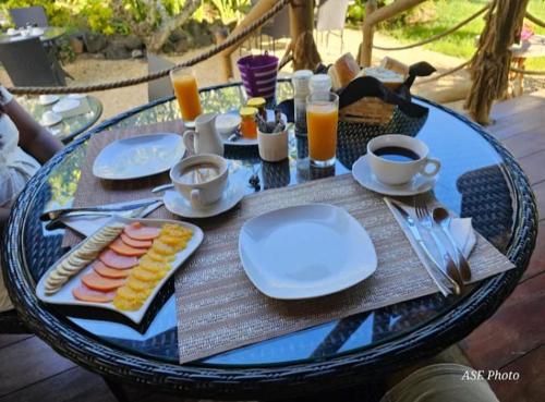 a table with plates of food and drinks on it at Garden lodge in Pereybere