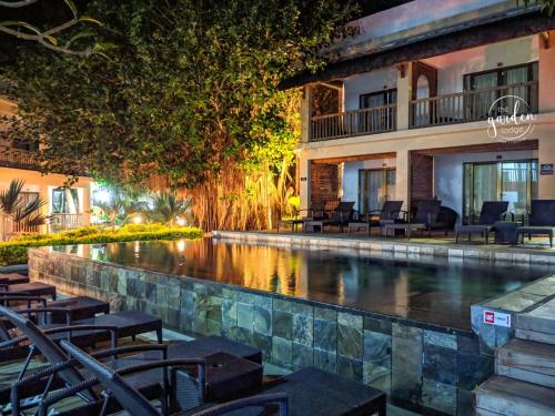 a swimming pool in front of a hotel at night at Garden lodge in Pereybere