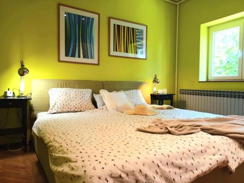 a bedroom with a large bed with green walls at Jane's Garden in Matulji