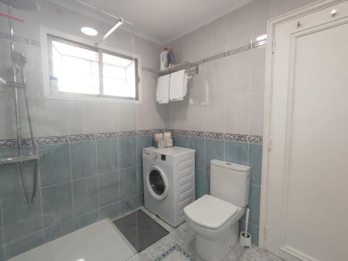a bathroom with a toilet and a washing machine at Vivienda Agaete Parque in Playa del Ingles