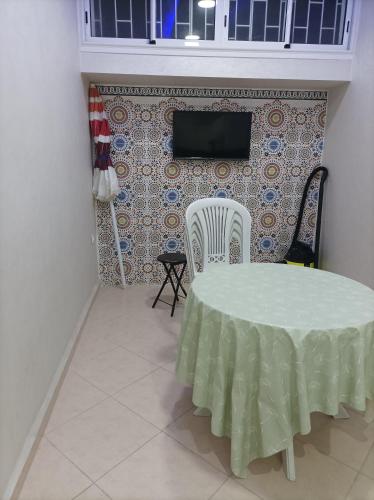Habitación con mesa, 2 sillas y TV. en Au cœur d'Agadir en Agadir