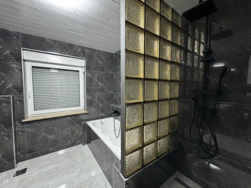 a bathroom with a shower and a tub and a window at Lux apartments Crystal-center in Bihać