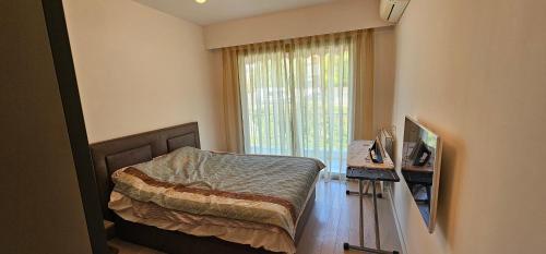 une chambre avec un lit et une grande fenêtre dans l'établissement bella d'azur, à Nice