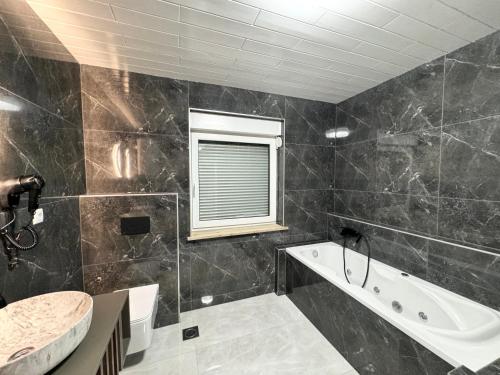 a bathroom with a tub and a sink at Lux apartments Crystal-center in Bihać