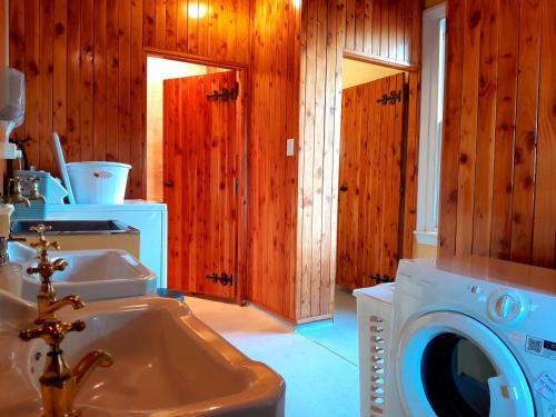 uma casa de banho com uma máquina de lavar roupa e um lavatório em Peter's Farm Lodge em Waipiata