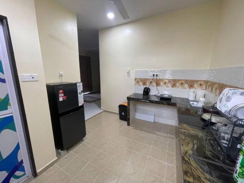 a kitchen with a counter and a sink and a refrigerator at Homestay ZR in Kuala Berang