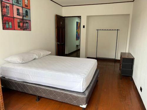 una camera con un letto bianco e una porta di Sabana Green House a Hatillo