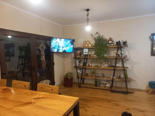 a living room with a wooden table and a television at Acogedora y amplia Casa in Puchuncaví