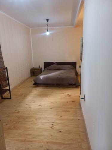 a bedroom with a bed and a wooden floor at Acogedora y amplia Casa in Puchuncaví