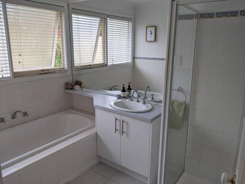 a bathroom with a sink and a tub and a shower at beach house in Venus Bay