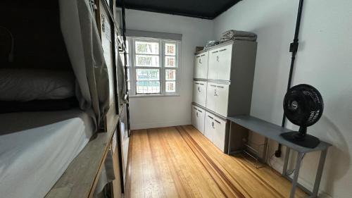 庫里奇巴的住宿－Hostel Hug Brasil，一间卧室配有一张床、一张书桌和一个窗户。