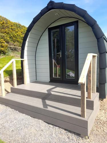 a small dome house with a wooden deck at Siabod Huts in Betws-y-coed