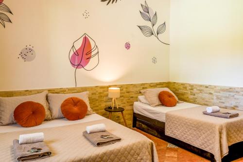 a room with two beds with orange pillows at Bella casa da paz in Búzios